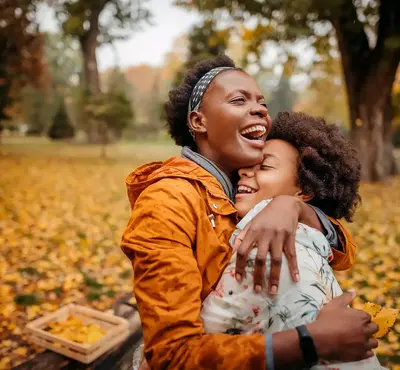 a woman hugging a child in a park