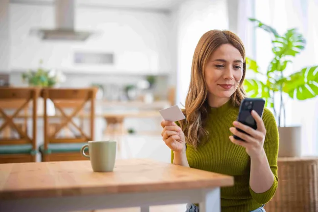 A woman sitting at the table looking at her phone