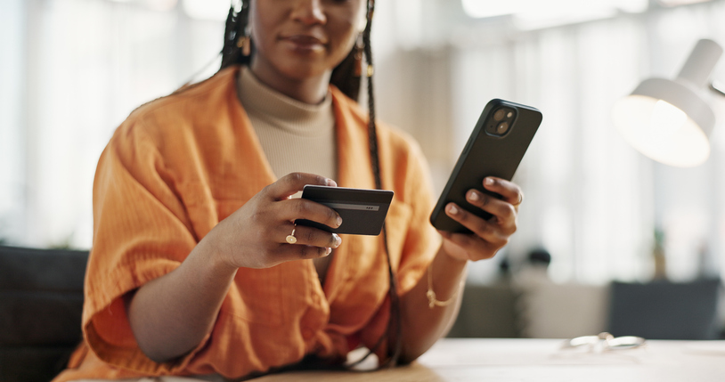 A entering their debit card information on their phone.