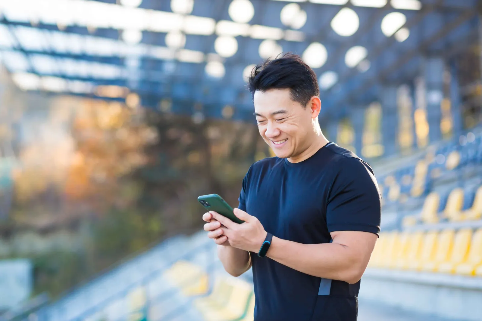 A man smiling looking at his phone