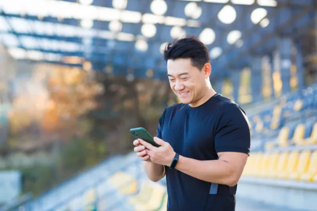 A man smiling looking at his phone