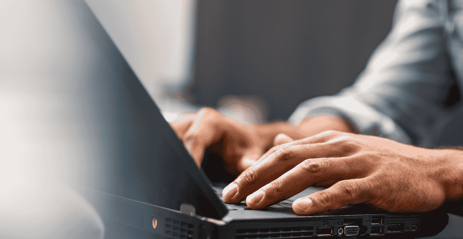 Close-up of hands typing on a laptop, representing online banking and digital convenience.
