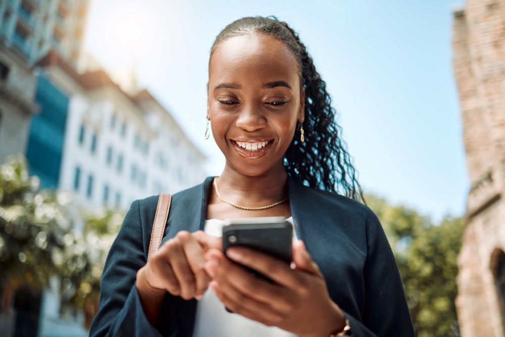 Woman smiling looking down at cellphone