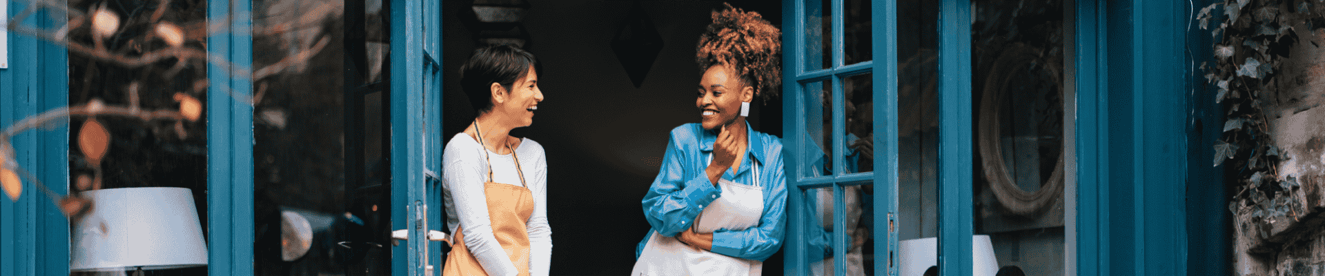 Two small business owners smiling, symbolizing success, partnership, and local entrepreneurship.