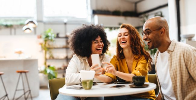 Friends smiling and browsing social media together