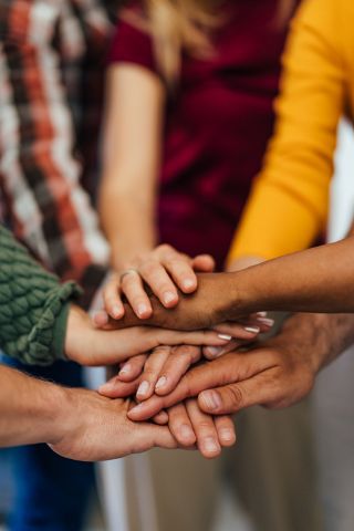 Diverse group of people putting hands together