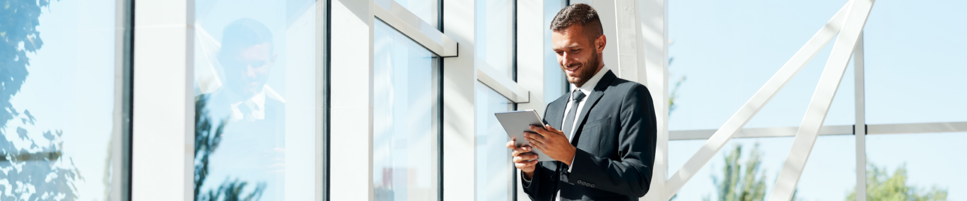 Businessman using a tablet, representing modern banking, digital tools, and financial management on the go.