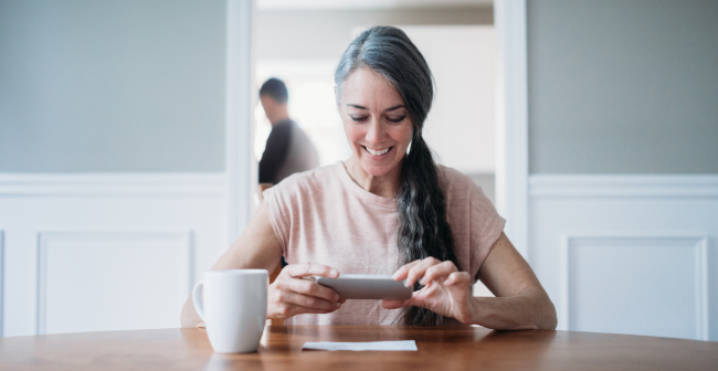 Woman photographing a check for mobile deposit, showcasing convenient digital banking.